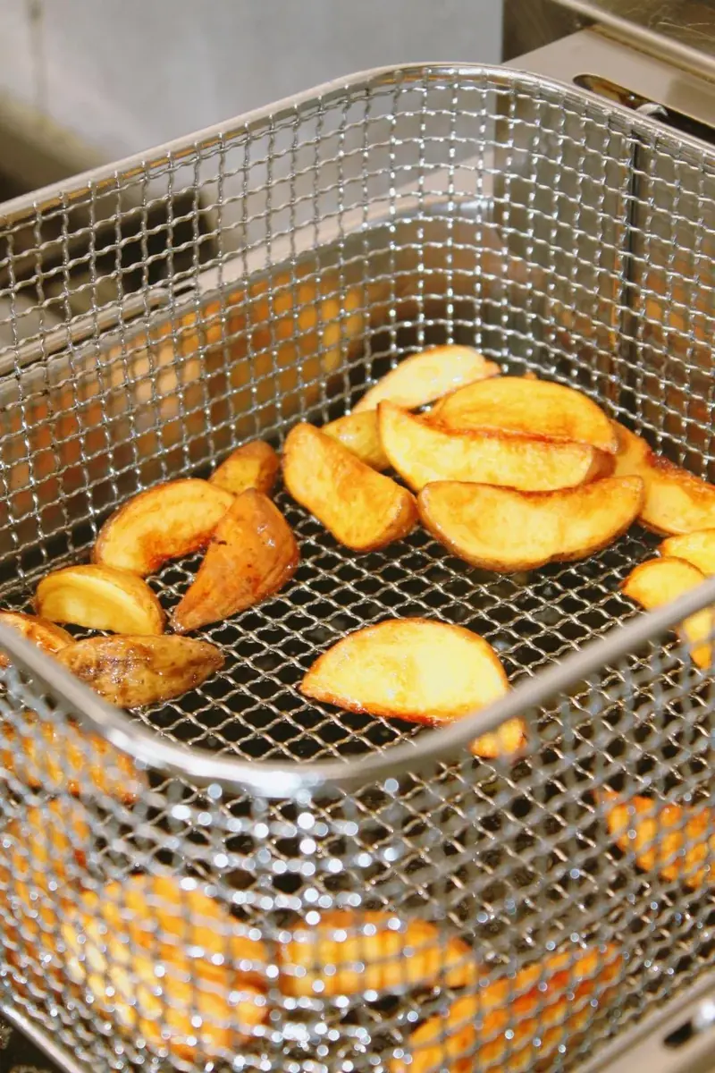 Patatas fritas crujientes en cesta de freidora de aceite — resultado típico de air fryer a 200°C