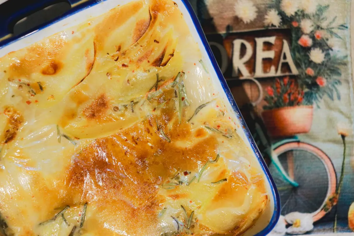 Gratinado de patatas con queso dorado en bandeja cerámica — resultado típico del modo grill del microondas