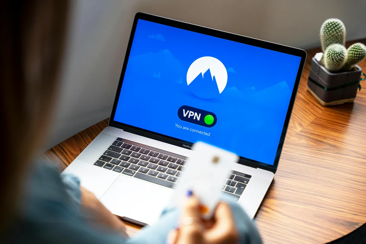 Persona seleccionando un servidor en España en la aplicación de VPN desde su laptop en casa — paso clave antes de abrir RTVE o Atresplayer