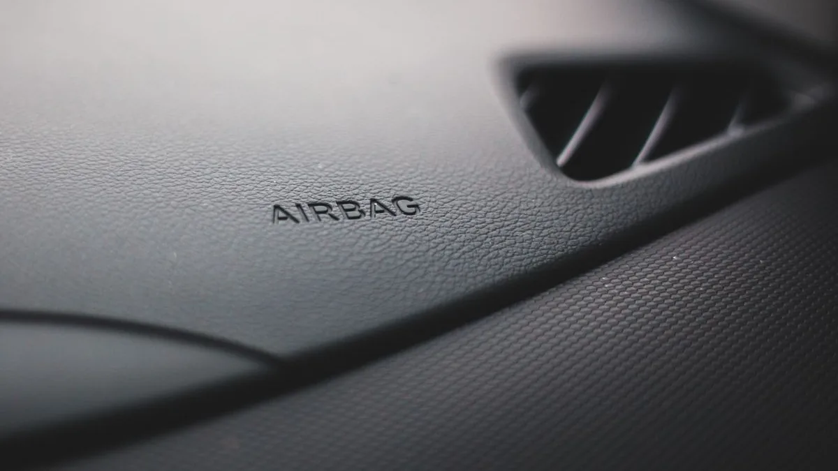 Detalhe do painel de um carro com a inscrição AIRBAG e uma saída de ar.